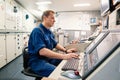 Marine engineer officer controlling vessel engines and propulsion in engine control room