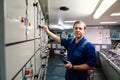 Marine engineer officer controlling vessel engines and propulsion in engine control room