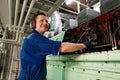 Marine engineer officer controlling vessel enginesand propulsion in engine control room ECR