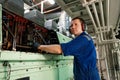 Marine engineer officer controlling vessel enginesand propulsion in engine control room ECR