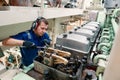 Marine engineer officer controlling vessel enginesand propulsion in engine control room ECR