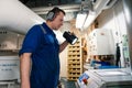 Marine engineer officer controlling vessel enginesand propulsion in engine control room ECR