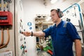 Marine engineer officer controlling vessel enginesand propulsion in engine control room ECR