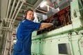 Marine engineer officer controlling vessel enginesand propulsion in engine control room ECR