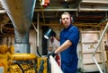 Marine engineer officer controlling vessel enginesand propulsion in engine control room ECR