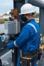 Marine engineering officer with protective mask doing work on the seagoing vessel