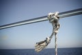 Marine Knot Detail Stainless Steel Boat Railing. Marine Fender Knot Around Boat Lee. Close-up nautical knot rope on sail boat Royalty Free Stock Photo