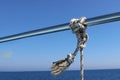 Marine Knot Detail Stainless Steel Boat Railing. Marine Fender Knot Around Boat Lee. Close-up nautical knot rope on sail boat Royalty Free Stock Photo