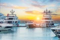 Marine parking of modern motor boats and blue water. Luxury yachts docked in sea port at sunset. Tranquility, relaxation and Royalty Free Stock Photo