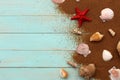Seashells lie on the sand on a wooden background. Royalty Free Stock Photo
