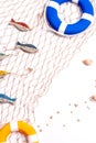 Marine still life: wooden fish, shells and two lifebuoys on a white background in a sea net