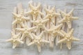 Marine summer Wallpaper. beige starfish on driftwood sticks on white shabby chic board background.Summer nautical decor