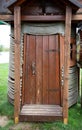 Marine toilet with wooden door and rope walls, close-up