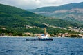 The marine tugboat sails along the coastline