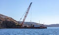 Marine work near Mykonos island port. Cyclades Greece. Construction machine, crane and barge on site