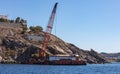 Marine work near Mykonos island port. Cyclades Greece. Construction machine, crane and barge on site