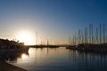 Marine yacht club at sunset in Alghero, Sardinia, Italy. Luxury yachts docked in seaport under colourful sundown. Warm orange Royalty Free Stock Photo