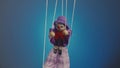 Marionette clown hanging on strings. A rag doll in a purple suit and hat, with a red bow, nose and makeup. Soft doll Royalty Free Stock Photo