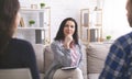 Attentive psychologist listening to married couple during session