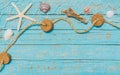 Maritime background, starfish and seashells in fishing net on turquoise blue wood Royalty Free Stock Photo