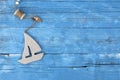 Maritime Decoration with shells, starfish, sailing ship, fishing net on blue drift wood Royalty Free Stock Photo