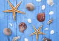 Maritime Decoration with shells, starfish, sailing ship, fishing net on blue drift wood Royalty Free Stock Photo