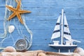 Maritime Decoration with shells, starfish, sailing ship, fishing net on blue drift wood