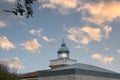 Maritime lighthouse lit with sunset sky