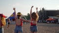 2021-08-08 - Mariupol City Festival, Ukraine. Festivalgoers in red tops, denim shorts walk at music event, hold drinks