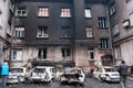 MARIUPOL, UKRAINE - March. 5, 2022: War of Russia against Ukraine. Residential Building and civil cars damaged by bombs