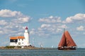 Marken lighthouse and traditional sailing boat under Dutch blue sky Royalty Free Stock Photo