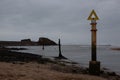 Marker posts at Bude Harbour in Bude, Cornwall with the breakwater in the background. Royalty Free Stock Photo