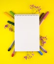 Markers of different colors with a white Notepad on a yellow background, top view Royalty Free Stock Photo