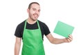 Market employee holding green cardboard and smiling