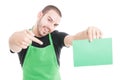 Market employee pointing green cardboard and smiling