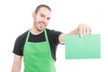 Market employee showing green cardboard and smiling