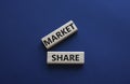 Market Share symbol. Wooden blocks with words Market Sharer. Beautiful deep blue background. Business and Market Share concept.