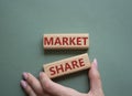 Market Share symbol. Wooden blocks with words Market Sharer. Beautiful grey green background. Businessman hand. Business and