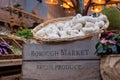 Borough Market, market in Southwark, London UK, with wide range of food stalls. Wooden crate and basket of garlic in foreground.