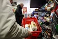 Market store customer holding plastic basket with groceries waiting in line to pay in front of cash register. IDEA IS big market r