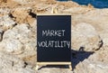 Market volatility symbol. Concept words Market volatility on beautiful black chalk blackboard. Chalkboard. Beautiful stone sea sky Royalty Free Stock Photo
