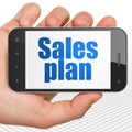 Marketing concept: Hand Holding Smartphone with Sales Plan on display Royalty Free Stock Photo