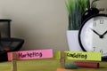 Marketing and Consulting. Handwriting on sticky notes in clothes pegs on wooden office desk