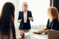 Marketing experts sit around table and looking at woman speaker at meeting. Royalty Free Stock Photo