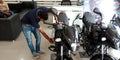 marketing staff displaying motorcycle latest model into the bajaj showroom in India