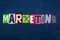 MARKETING text word collage, multi colored fabric on blue denim, sales and marketing concept