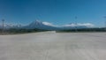 Marking lines and tire tracks are visible on the concrete runway of the airfield.