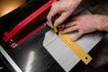 Marking the tiles with a yellow ruler and a pencil for cutting with an electric tile cutter horizontal Royalty Free Stock Photo