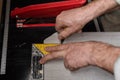 a marking the tiles with a yellow ruler and a pencil for cutting with an electric tile cutter Royalty Free Stock Photo