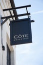 The Cote Brasserie sign hanging from a wall in the UK